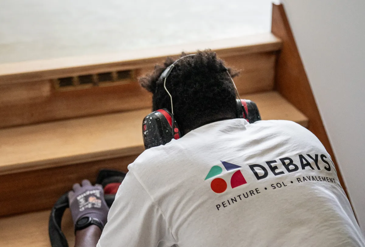 Compagnon DEBAYS ponçant les marches d’un escalier