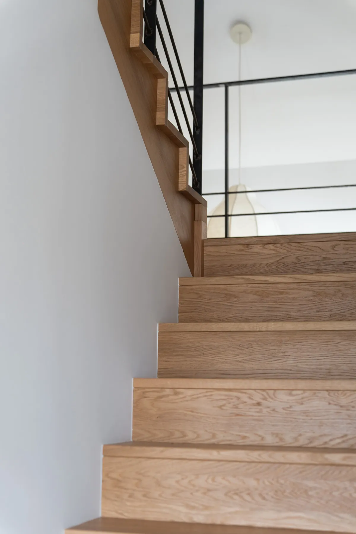 Escalier en chêne le long d’un mur blanc